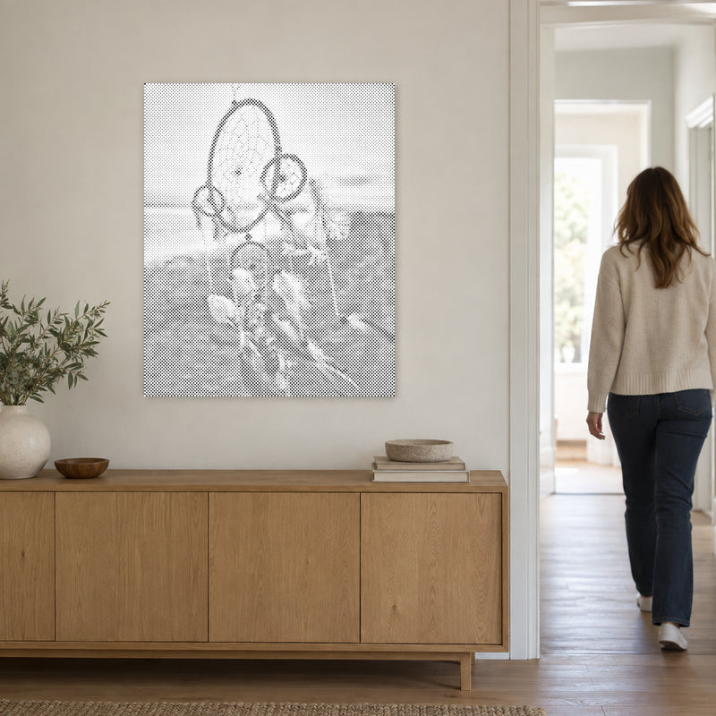 Punktmalerei-Leinwand “Traumfänger im Wind”, an einer hellen Wand, während eine Person durch die Tür geht.