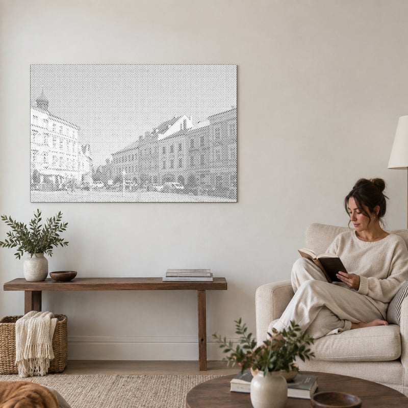 Punktmalerei-Leinwand “Jindřichův Hradec”, an einer Wohnzimmerwand, daneben liest eine Person in einem Sessel.